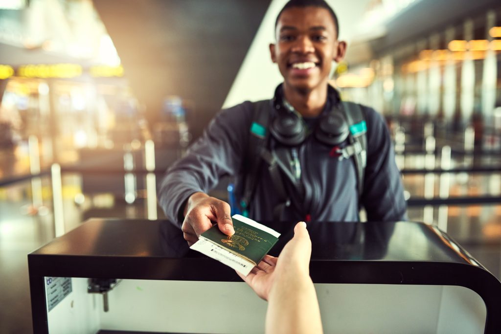 Passenger showing an ID card during check-in at a travel counter